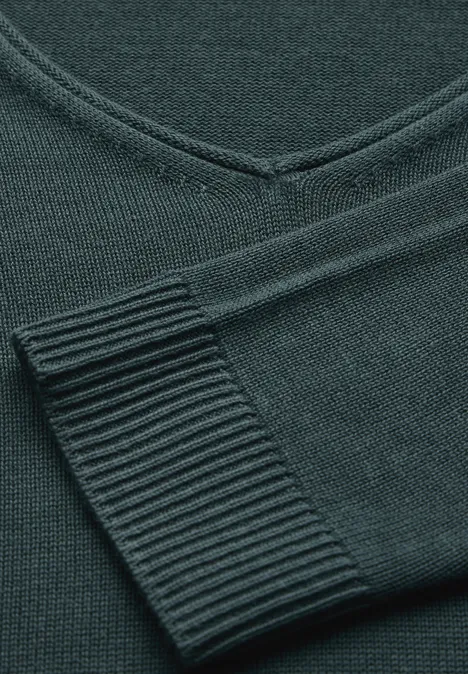 Dunkelgrüner, gestrickter Pullover mit V-Ausschnitt und geripptem Ärmelbündchen.